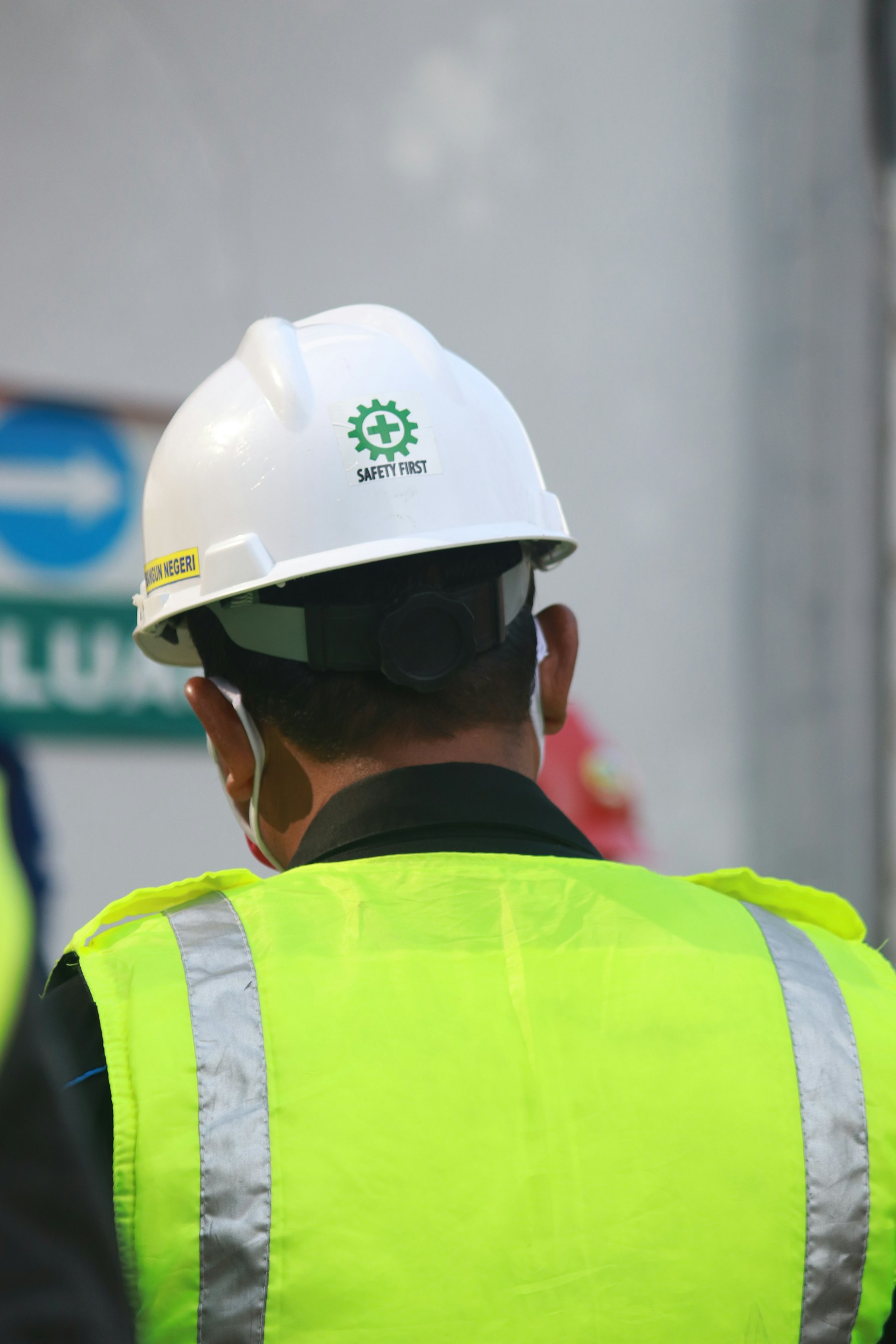 Engineer wearing a white hard hat and high-visibility vest
